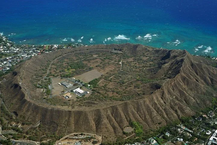 Aerial view of a large volcanic crater near the ocean coastline.