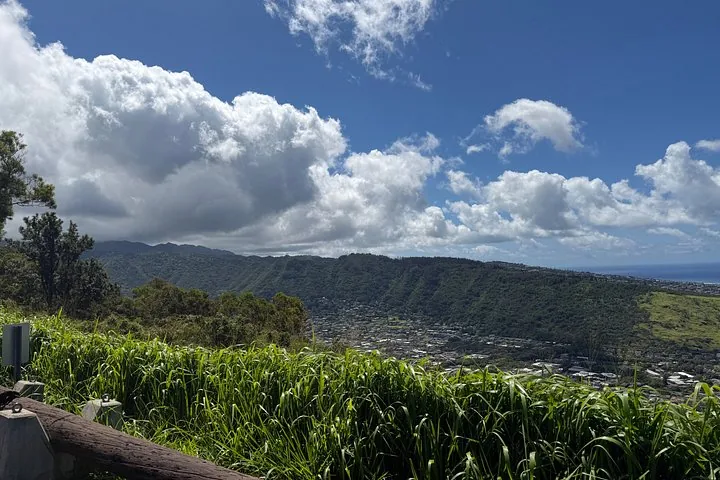 A scenic view of a city nestled in a valley surrounded by green hills.